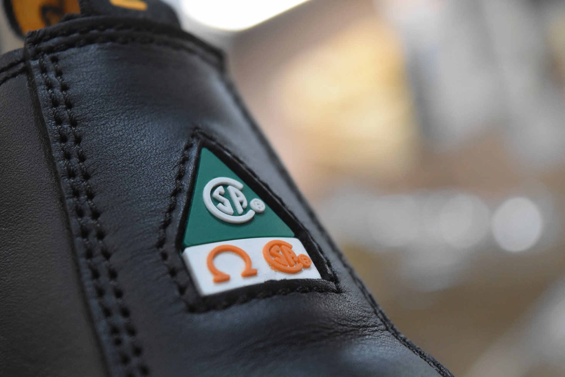 Close-up Black Leather CSA Green Triangle and Omega Symbol