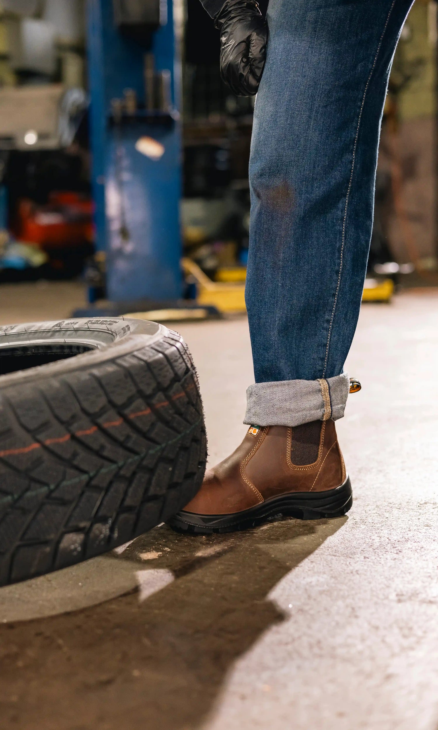 Person wearing brown chelsea safety boots while being crushed by a tire.