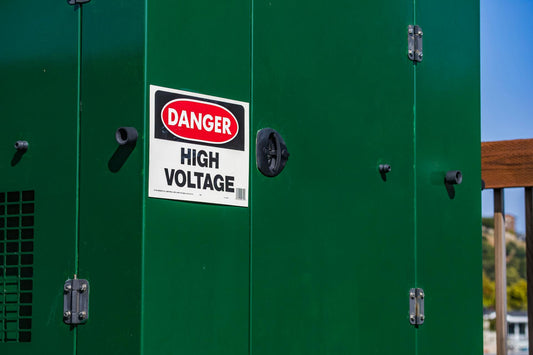 Danger high voltage safety sign on green industrial electrical cabinet outdoors