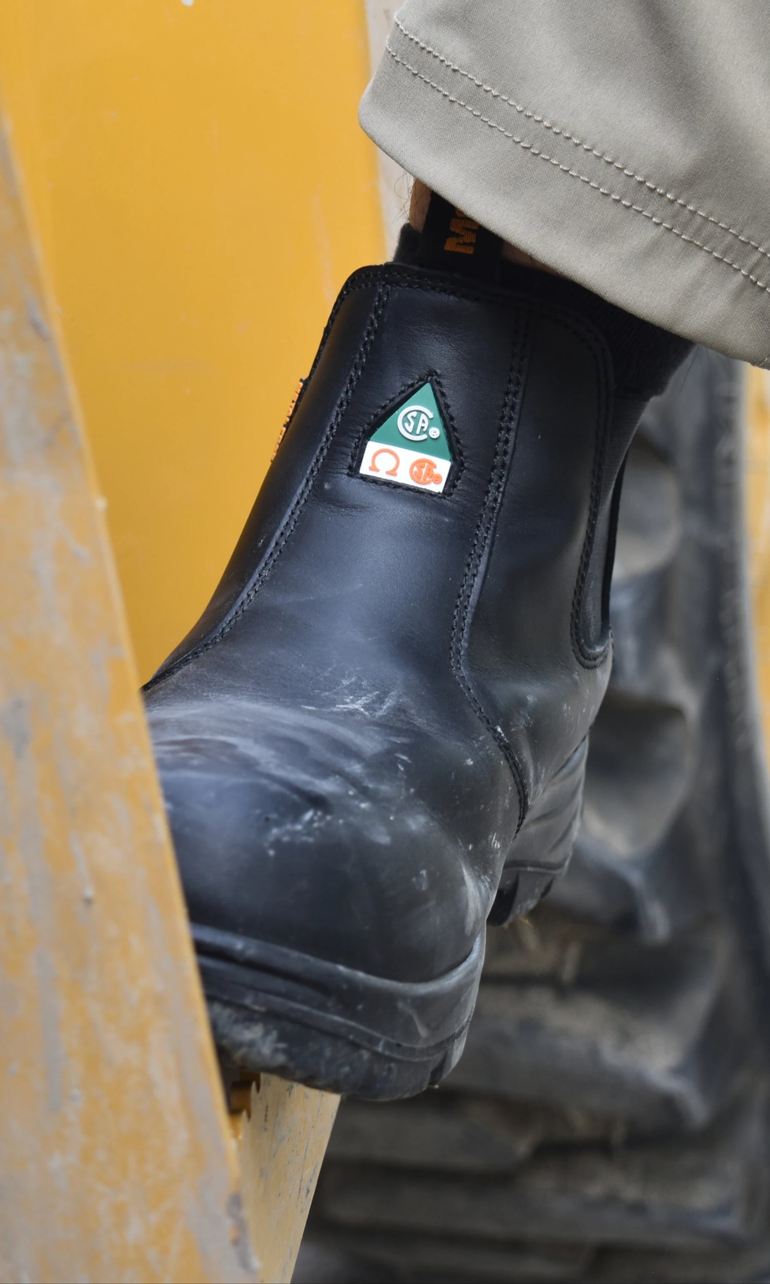 Black work boot with a csa logo on a yellow background